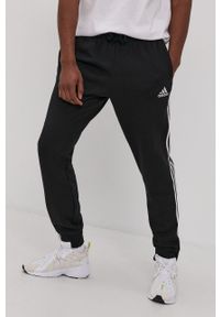 Adidas - adidas Spodnie męskie kolor czarny z aplikacją. Kolor: czarny. Wzór: aplikacja