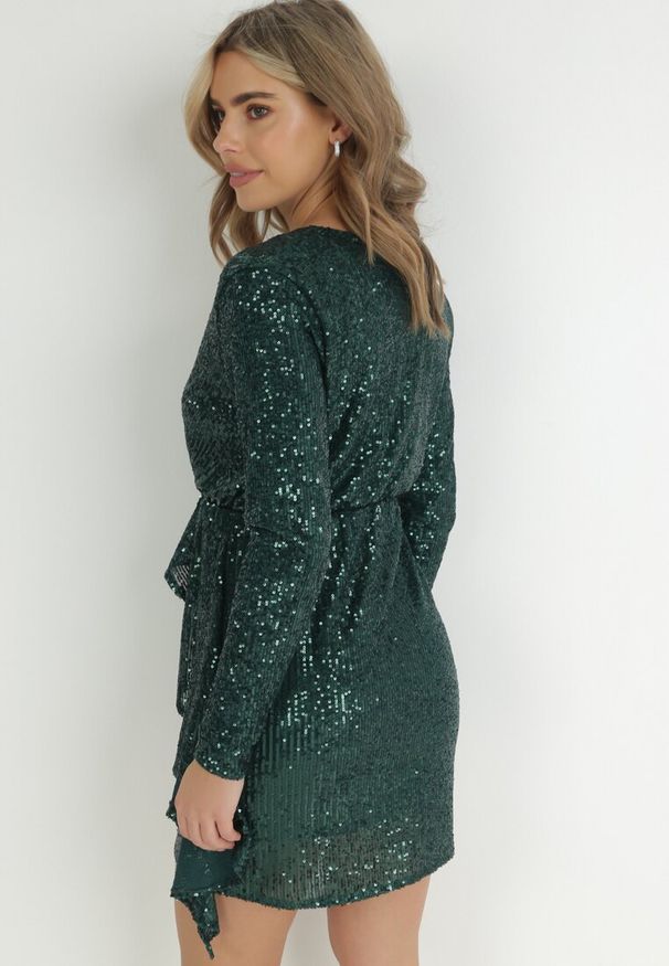 Born2be - Ciemnozielona Cekinowa Sukienka Mini z Kopertowym Dekoltem Missi. Okazja: na sylwestra. Typ kołnierza: dekolt kopertowy. Kolor: zielony. Materiał: materiał. Wzór: aplikacja. Typ sukienki: kopertowe. Długość: mini