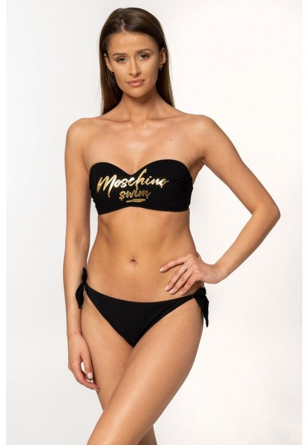 MOSCHINO Czarny dół od bikini z wiązaniami i złotym logo. Kolor: czarny. Wzór: aplikacja, nadruk