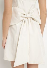 Born2be - Beżowa Rozkloszowana Sukienka na Ramiączkach Zdobiona Dużą Kokardą Lavvia. Okazja: na co dzień. Typ kołnierza: kokarda. Kolor: beżowy. Długość rękawa: na ramiączkach. Wzór: aplikacja. Typ sukienki: rozkloszowane. Styl: elegancki, casual #5