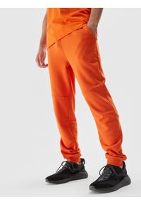 4f - Spodnie dresowe joggery męskie - pomarańczowe. Kolor: pomarańczowy. Materiał: dresówka