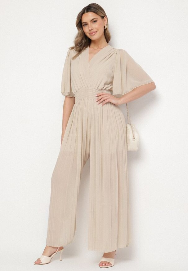 Born2be - Beżowy Plisowany Kombinezon o Kopertowym Kroju z Gumką w Talii Ameddie. Okazja: na co dzień. Kolor: beżowy. Styl: elegancki, casual