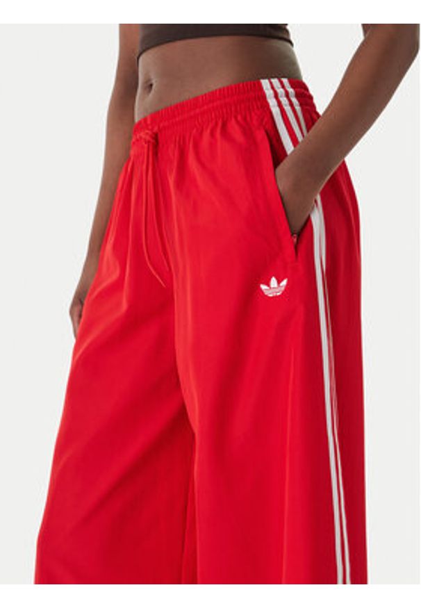 Adidas - adidas Spodnie dresowe Firebird Adilenium KD6299 Czerwony Regular Fit. Kolor: czerwony. Materiał: syntetyk