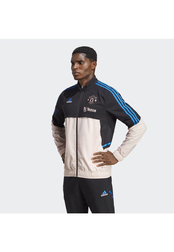 Adidas - Kurtka z dresu Manchester United Presentation Condivo 2022/23. Kolor: różowy, wielokolorowy, czarny. Materiał: dresówka. Sport: piłka nożna