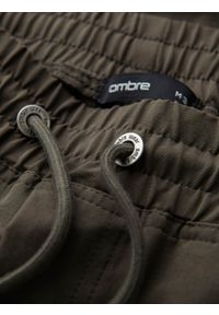 Ombre Clothing - Męskie spodnie joggery z kieszeniami cargo i printem – ciemnooliwkowe V5. Okazja: na co dzień. Kolor: oliwkowy. Materiał: guma, tkanina, poliester, materiał, bawełna, elastan. Wzór: nadruk. Styl: casual #9