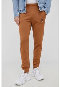 GAP spodnie x Disney męskie kolor brązowy z nadrukiem. Kolor: brązowy. Wzór: nadruk, motyw z bajki