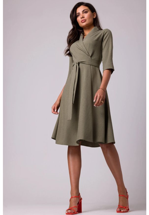 Sukienki.shop - Rozkloszowana sukienka kopertowa z wiązaniem w pasie khaki. Okazja: do pracy. Kolor: brązowy. Typ sukienki: kopertowe. Styl: elegancki, wizytowy