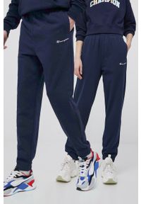 Champion spodnie 217404 kolor granatowy z aplikacją. Kolor: niebieski. Materiał: włókno, dzianina, materiał. Wzór: aplikacja #1