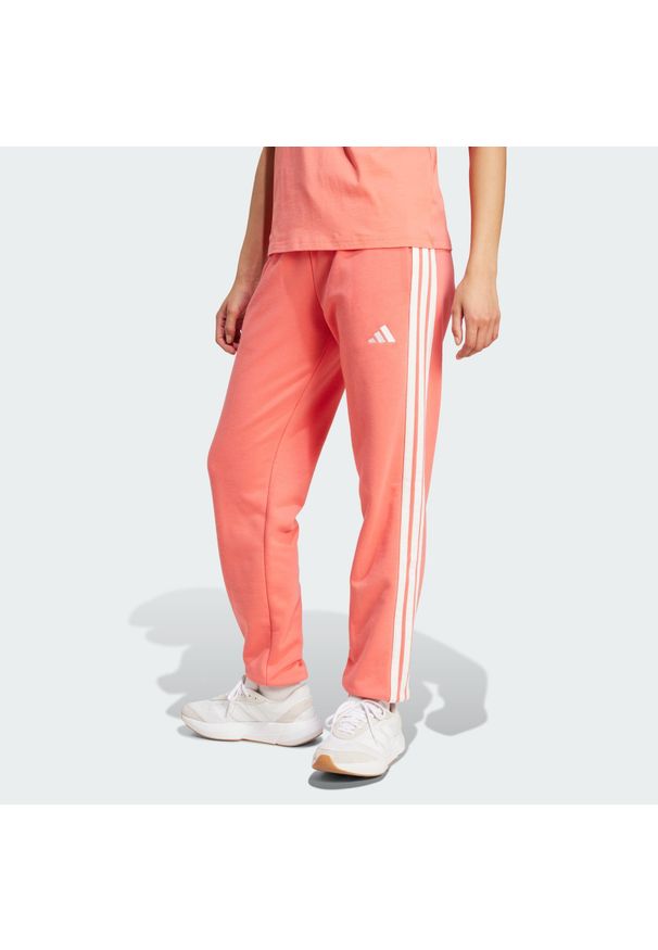 Adidas - Spodnie Essentials 3-Stripes French Terry Cuffed. Kolor: żółty, biały, pomarańczowy, wielokolorowy. Materiał: materiał