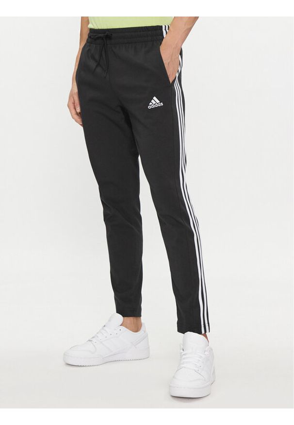 Adidas - adidas Spodnie dresowe Essentials Single Jersey Tapered Open Hem 3-Stripes Joggers IC0044 Czarny Regular Fit. Kolor: czarny. Materiał: bawełna