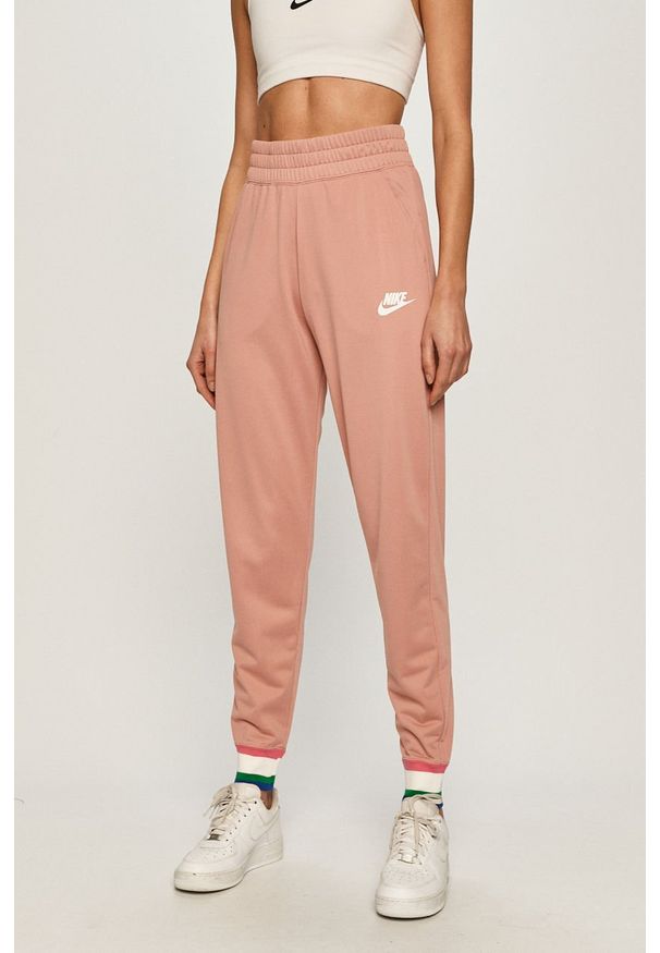Nike Sportswear - Spodnie. Kolor: różowy. Materiał: tkanina, poliester. Wzór: gładki