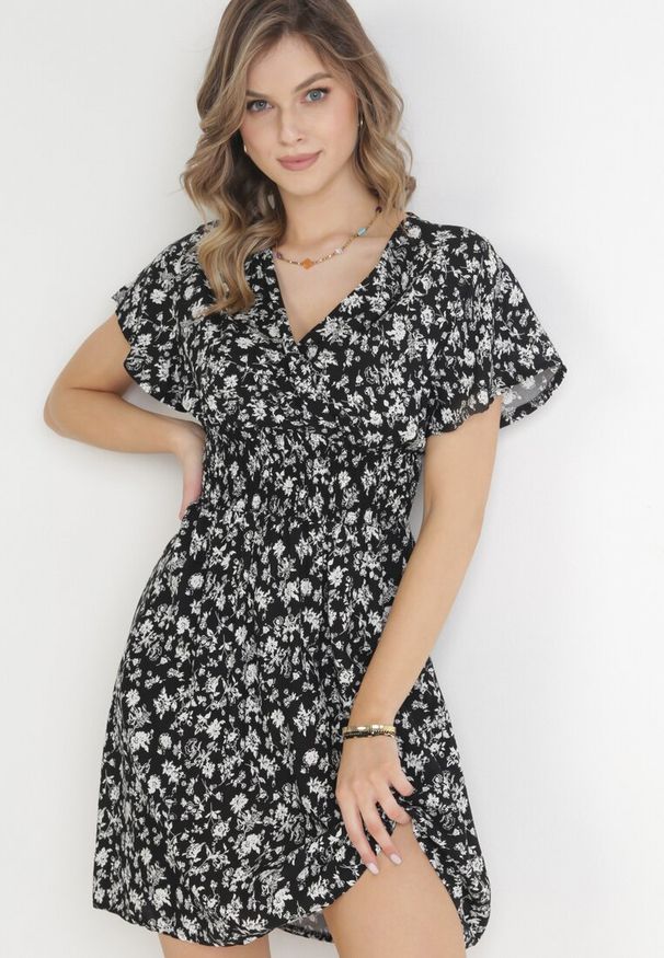 Born2be - Czarna Kwiecista Sukienka Mini z Wiskozy z Marszczoną Gumką w Pasie Catela. Kolor: czarny. Materiał: wiskoza. Długość rękawa: krótki rękaw. Wzór: kwiaty. Sezon: wiosna, lato. Typ sukienki: rozkloszowane, kopertowe. Długość: mini