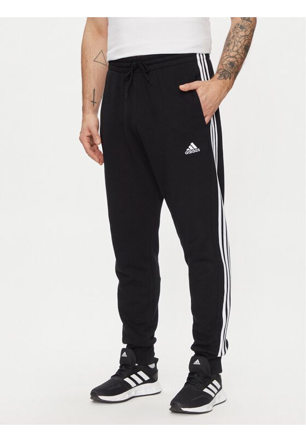 Adidas - adidas Spodnie dresowe Essentials French Terry Tapered Cuff 3-Stripes Joggers HA4337 Czarny Regular Fit. Kolor: czarny. Materiał: bawełna