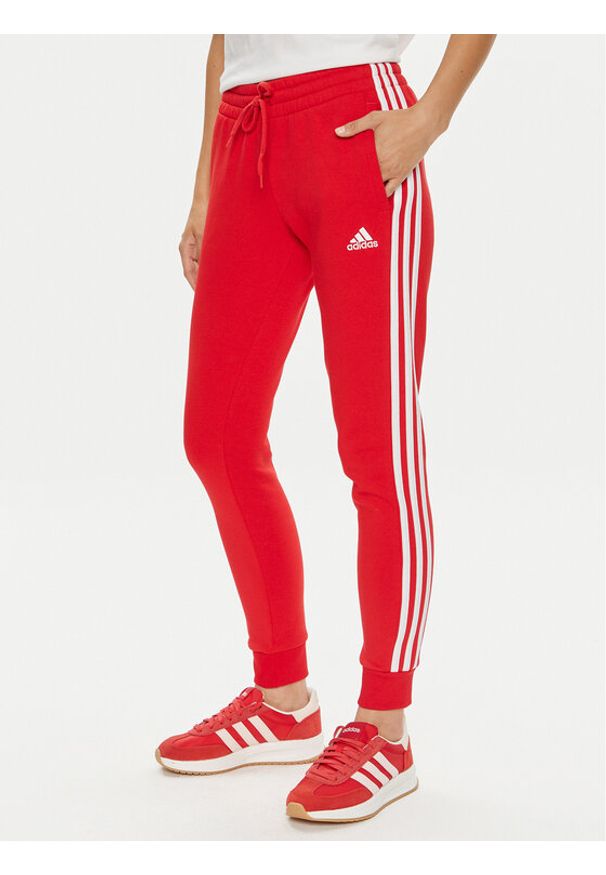 Adidas - adidas Spodnie dresowe Essentials 3-Stripes IY1719 Czerwony Slim Fit. Kolor: czerwony. Materiał: bawełna