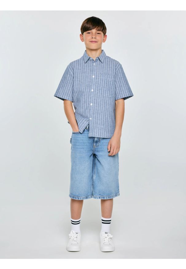 Big-Star - Koszula chłopięca oversize w prążek niebieska Wenling 401. Okazja: na co dzień. Kolor: niebieski. Materiał: bawełna, tkanina, len. Długość rękawa: krótki rękaw. Długość: krótkie. Wzór: prążki. Sezon: lato. Styl: elegancki, klasyczny, casual