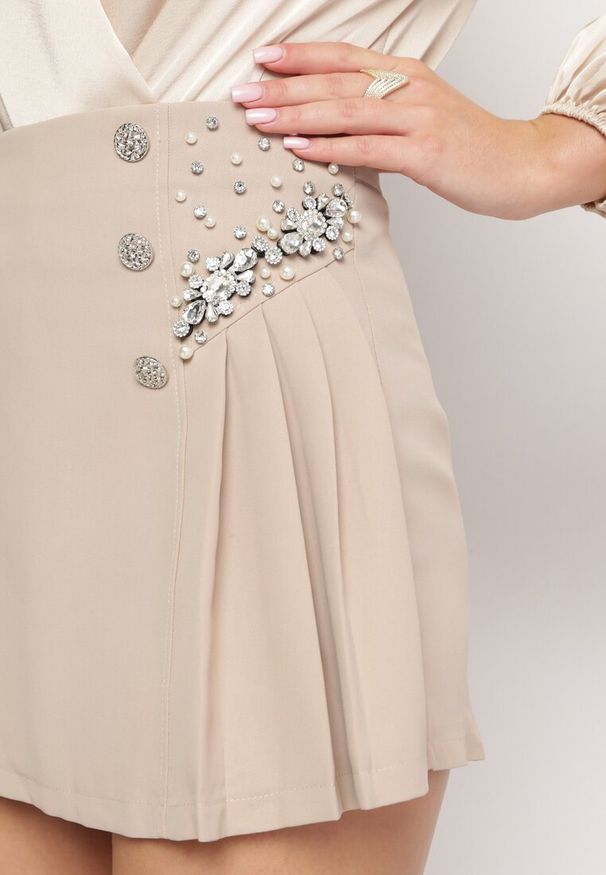 Born2be - Beżowe Szorty Spódnica z Ukrytym Suwakiem Ozdobione Cyrkoniami Perłami oraz Guzikami Nelile. Stan: podwyższony. Kolor: beżowy. Materiał: materiał. Długość: do kolan. Wzór: aplikacja