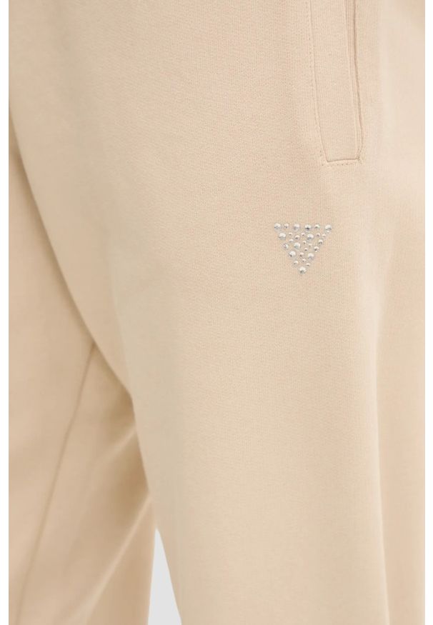 Guess - GUESS Beżowe damskie spodnie dresowe Primula. Kolor: beżowy. Materiał: dresówka