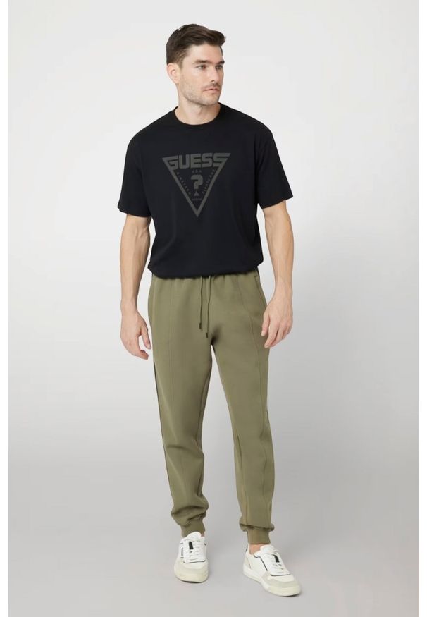Guess - GUESS Zielone męskie spodnie dresowe z lampasami Mickey, Rozmiar XL. Kolor: zielony. Materiał: dresówka
