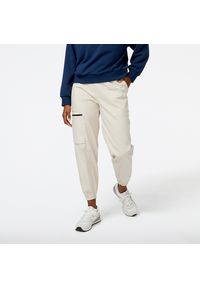 Spodnie damskie New Balance WP31506TWF – beżowe. Kolor: beżowy. Materiał: bawełna, nylon, materiał