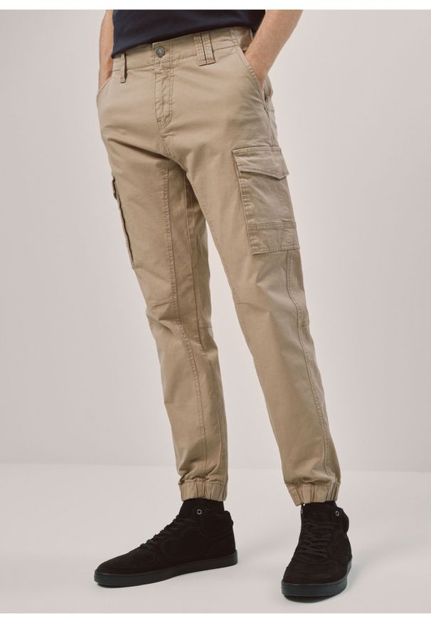 Ochnik - Beżowe spodnie męskie cargo. Kolor: beżowy. Materiał: bawełna