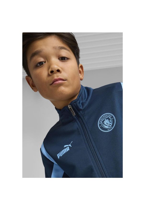 Puma - Młodzieżowa kurtka Manchester City ftblNRGY+ PUMA Marine Blue Blazing. Kolor: niebieski. Wzór: aplikacja