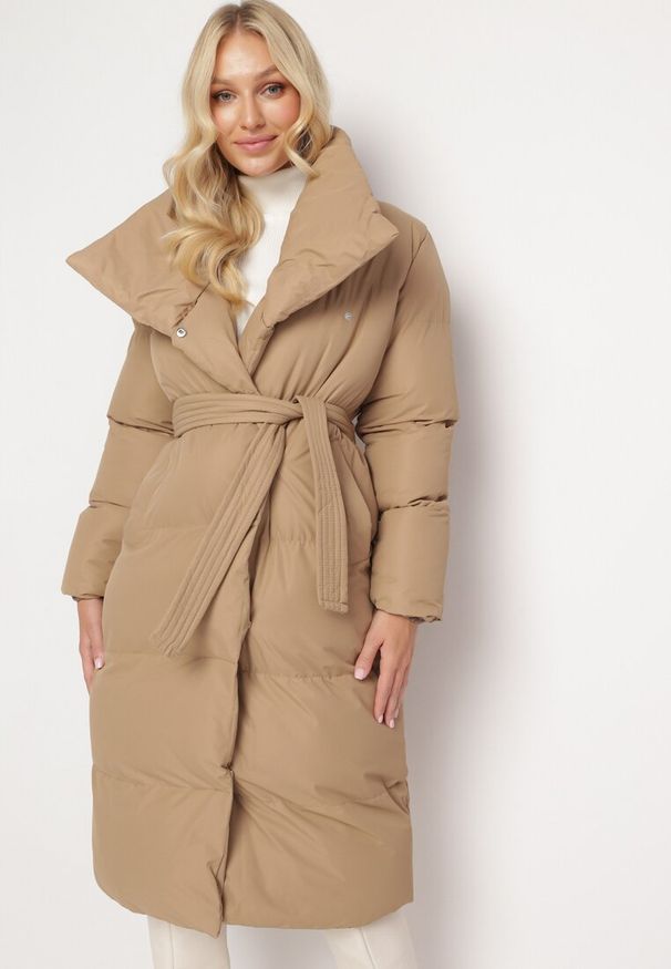 Born2be - Ciemnobeżowa Kurtka Płaszcz Zapinana na Napy Ukryte pod Plisą z Kieszeniami i Paskiem Ritallas. Typ kołnierza: kołnierzyk stójkowy. Kolor: beżowy. Materiał: materiał. Długość: długie. Sezon: zima