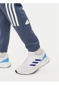 Adidas - adidas Spodnie dresowe Future Icons 3-Stripes IR9194 Niebieski Slim Fit. Kolor: niebieski. Materiał: bawełna