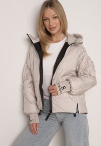 Born2be - Beżowa Przejściowa Kurtka Pikowana z Kapturem i Napisami na Rękawach Althone. Okazja: na co dzień. Typ kołnierza: kaptur. Kolor: beżowy. Materiał: poliester. Wzór: napisy. Styl: casual #1