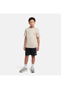 Koszulka dziecięca New Balance YT61A21ATWF – beżowa. Kolor: beżowy. Materiał: materiał, bawełna. Długość rękawa: krótki rękaw. Długość: krótkie. Wzór: aplikacja #3