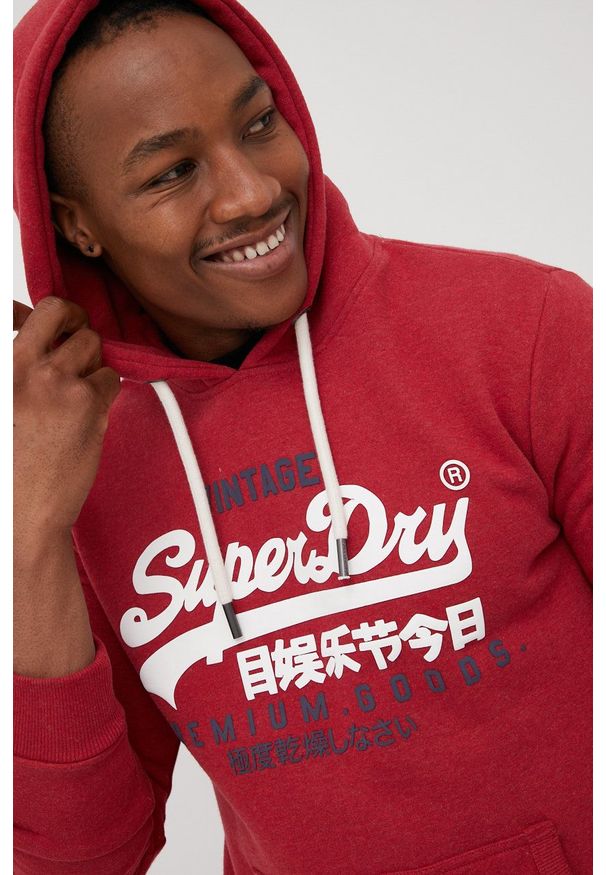Superdry bluza męska kolor czerwony z kapturem z aplikacją. Okazja: na co dzień. Typ kołnierza: kaptur. Kolor: czerwony. Materiał: dzianina. Wzór: aplikacja. Styl: casual
