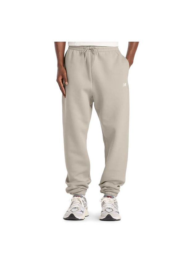 Spodnie męskie New Balance MP41503TWF - beżowe. Kolor: beżowy. Materiał: poliester, bawełna, dresówka, materiał