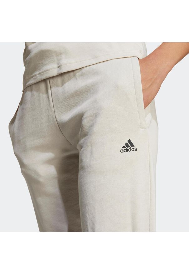 Adidas - Spodnie dresowe damskie ADIDAS Gym & Pilates. Kolor: beżowy. Materiał: bawełna, materiał. Sport: joga i pilates