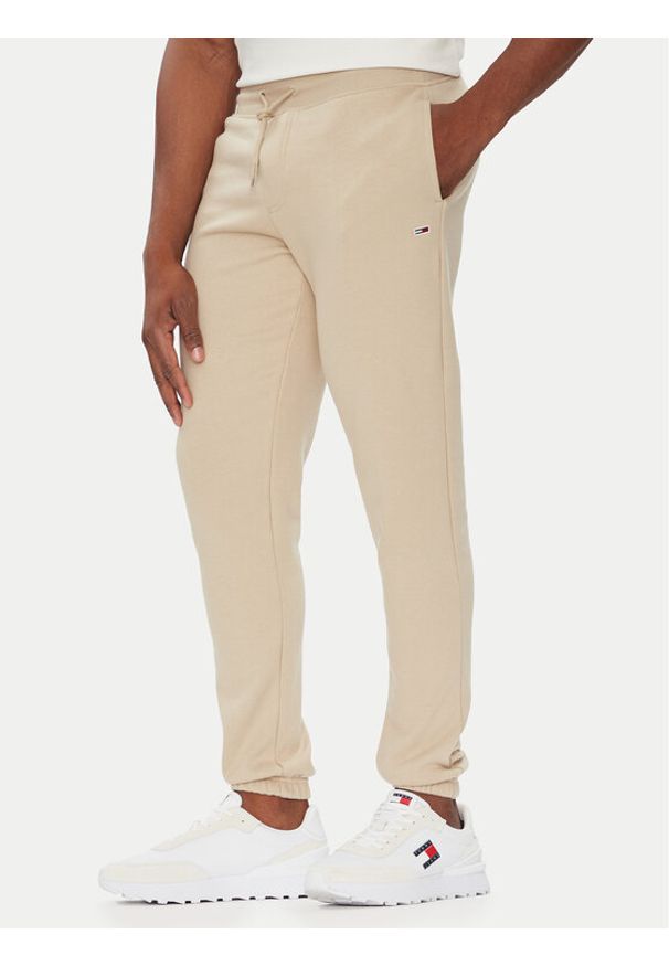 Tommy Jeans Spodnie dresowe Flag DM0DM20473 Beżowy Slim Fit. Kolor: beżowy. Materiał: bawełna