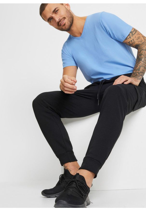 bonprix - Spodnie sportowe z kieszeniami cargo, regular fit. Kolor: czarny. Styl: sportowy
