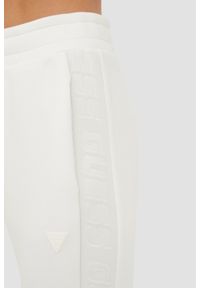 Guess - GUESS Beżowe spodnie dresowe damskie Allie Scuba, Rozmiar L. Kolor: beżowy. Materiał: dresówka #2