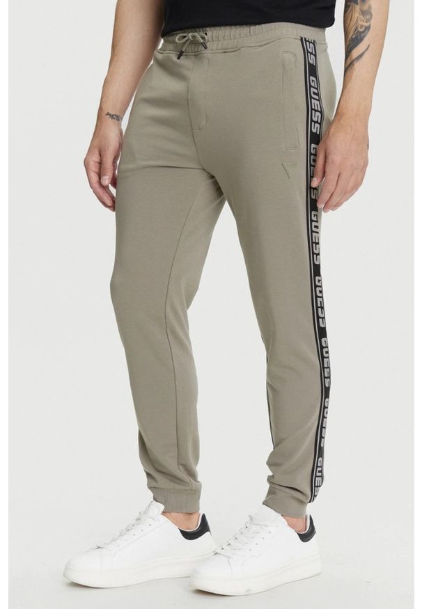 Guess - GUESS Zielone męskie spodnie dresowe z lampasami New Arlo, Rozmiar S. Kolor: zielony. Materiał: dresówka