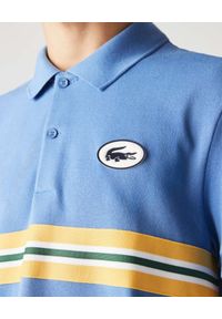 Lacoste - LACOSTE - Niebieska koszulka polo z paskami Regular Fit. Typ kołnierza: polo. Kolor: niebieski. Materiał: bawełna. Wzór: kolorowy. Styl: retro #3