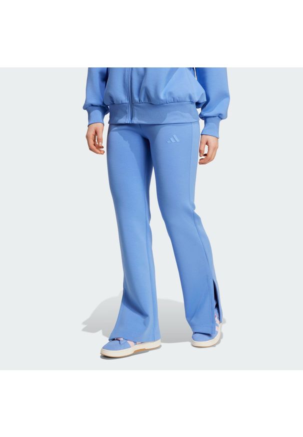 Adidas - Spodnie ALL SZN Soft Lux Flared. Kolor: niebieski