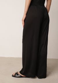 Born2be - Czarne Szerokie Spodnie z Teksturalnej Tkaniny z Ozdobnym Guzikiem Liphia. Okazja: do pracy, na co dzień, na spotkanie biznesowe. Stan: podwyższony. Kolor: czarny. Materiał: tkanina. Długość: długie. Styl: biznesowy, casual #8