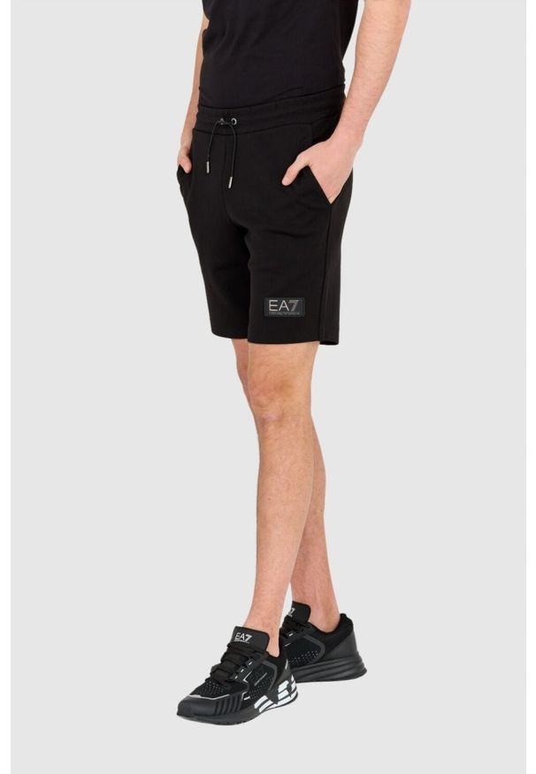 EA7 Emporio Armani - EA7 Krótkie czarne spodenki męskie z naszywką. Kolor: czarny. Materiał: poliester. Długość: krótkie. Wzór: aplikacja