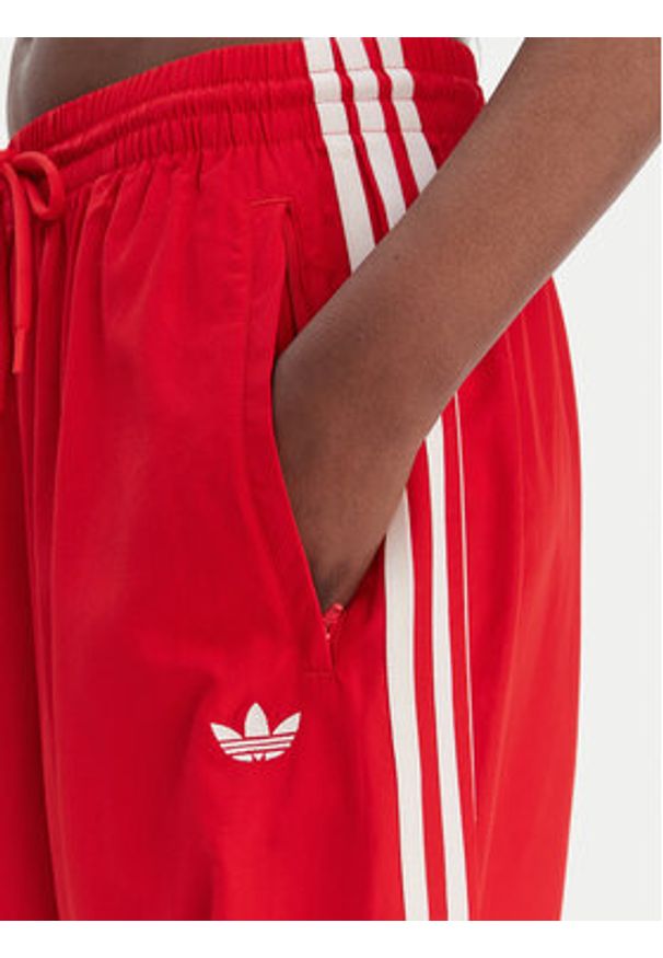 Adidas - adidas Spodnie dresowe Firebird Adilenium KD6299 Czerwony Regular Fit. Kolor: czerwony. Materiał: syntetyk