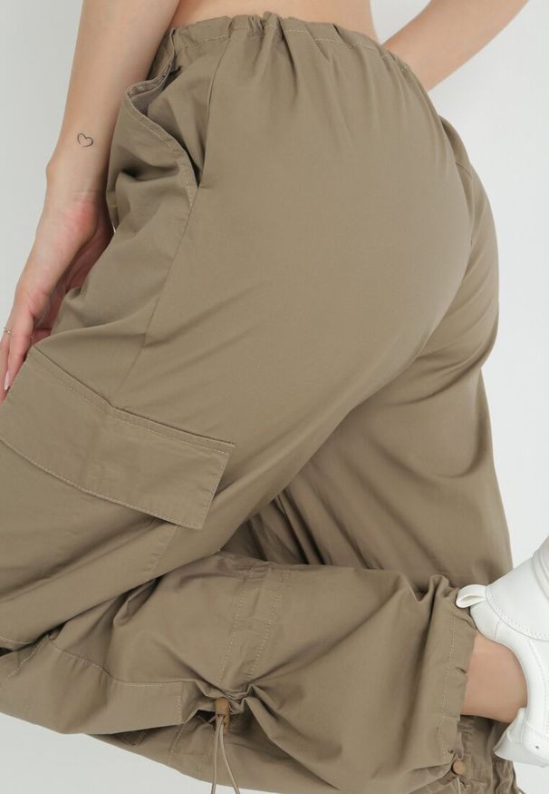 Born2be - Beżowe Spodnie Spadochronowe ze Stoperami w Talii i na Nogawkach Titalia. Kolor: beżowy