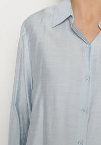 Born2be - Jasnoniebieska Koszula Oversize z Rękawami z Możliwością Podpięcia Sorria. Okazja: na co dzień. Kolor: niebieski. Materiał: jeans. Długość rękawa: długi rękaw. Długość: długie. Styl: klasyczny, casual, elegancki #3