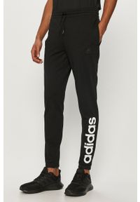 Adidas - adidas - Spodnie. Kolor: czarny. Materiał: bawełna, poliester, dzianina. Wzór: nadruk #1