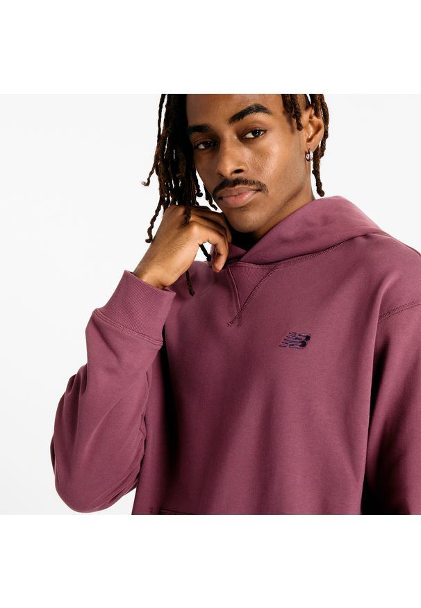 Bluza męska New Balance MT41534FDP – fioletowa. Typ kołnierza: kaptur. Kolor: fioletowy. Materiał: prążkowany, bawełna. Wzór: haft