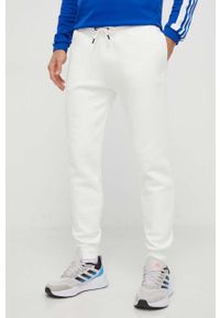 Guess spodnie dresowe kolor biały melanżowe. Kolor: biały. Materiał: dresówka. Wzór: melanż