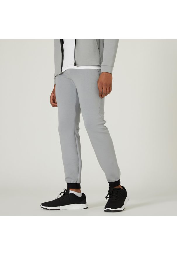 DOMYOS - Spodnie dresowe męskie Nyamba Gym & Pilates 540 slim. Kolor: szary. Materiał: materiał, bawełna, poliester, elastan. Wzór: ze splotem. Sport: joga i pilates