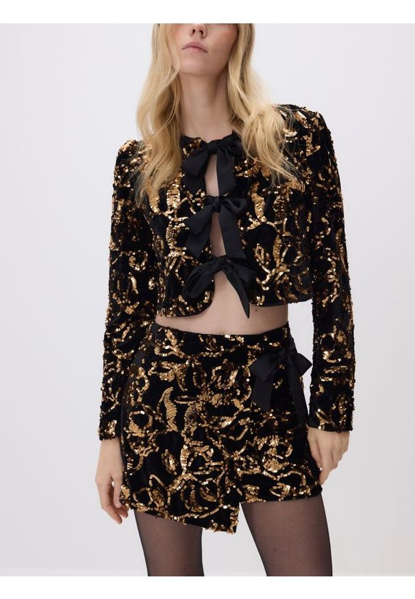 Reserved - Cekinowa marynarka z kokardami - czarny. Typ kołnierza: kokarda. Kolor: czarny. Materiał: dzianina. Długość: krótkie