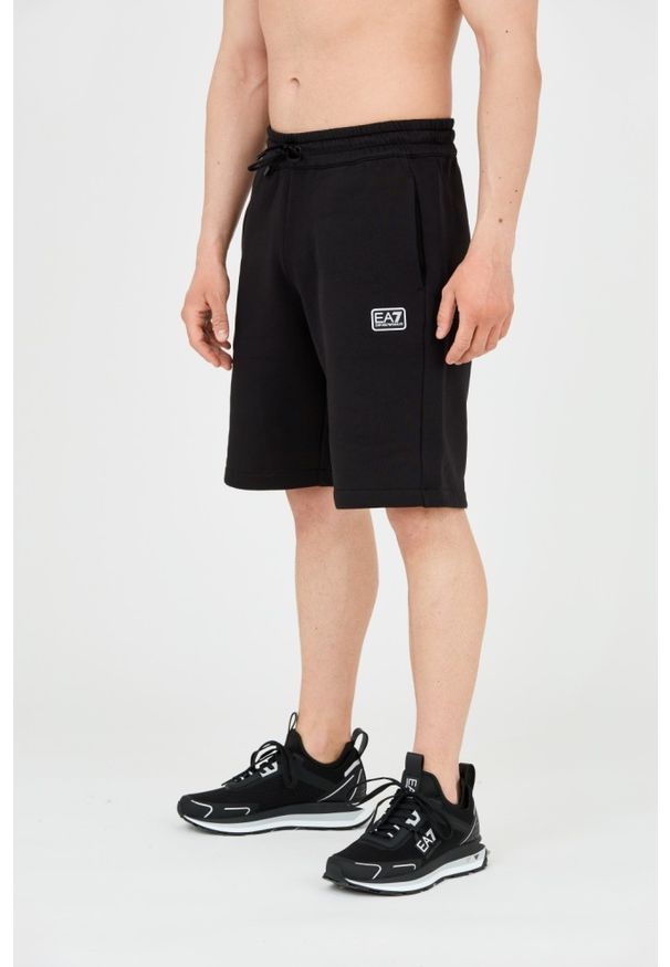 EA7 Emporio Armani - EA7 Męskie czarne krótkie spodenki z naszywkę. Kolor: czarny. Materiał: bawełna. Długość: krótkie. Wzór: aplikacja