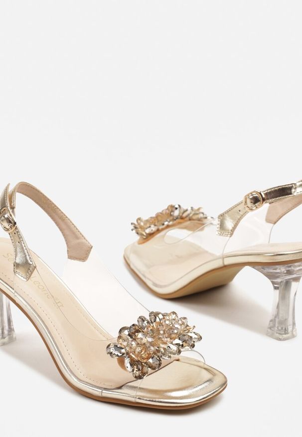 Renee - Złote Transparentne Sandały Peep Toe na Szpilce z Odkrytą Piętą i Ozdobną Aplikacją Giggie. Nosek buta: otwarty. Zapięcie: sprzączka. Kolor: złoty. Wzór: aplikacja. Obcas: na szpilce. Styl: wizytowy